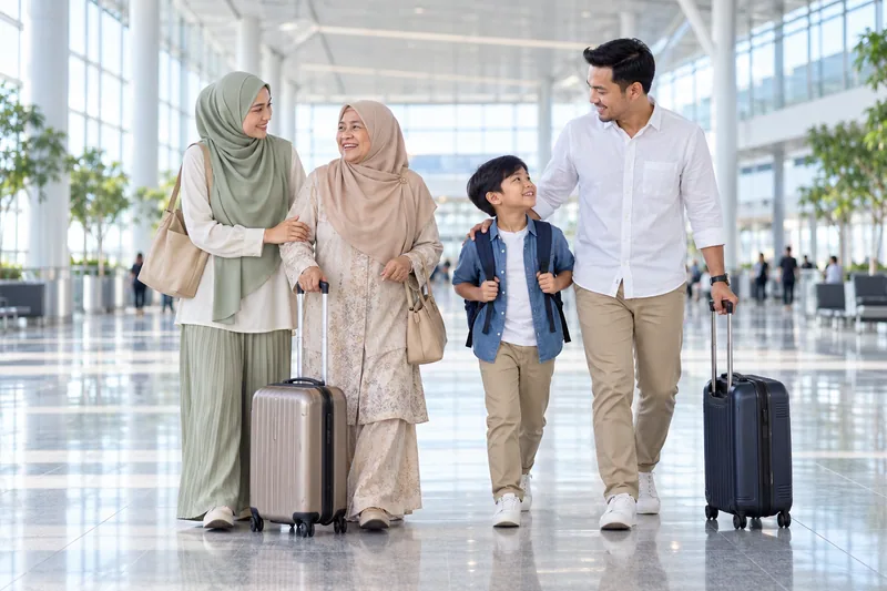 A family travels together through an airport concourse